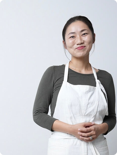 エプロン姿で微笑む女性の写真