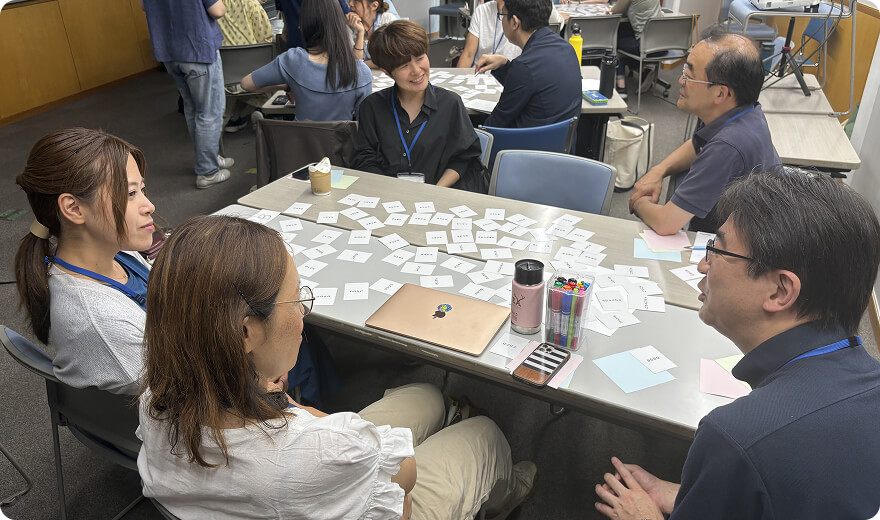 テーブルで数名で話しをする人たちの写真