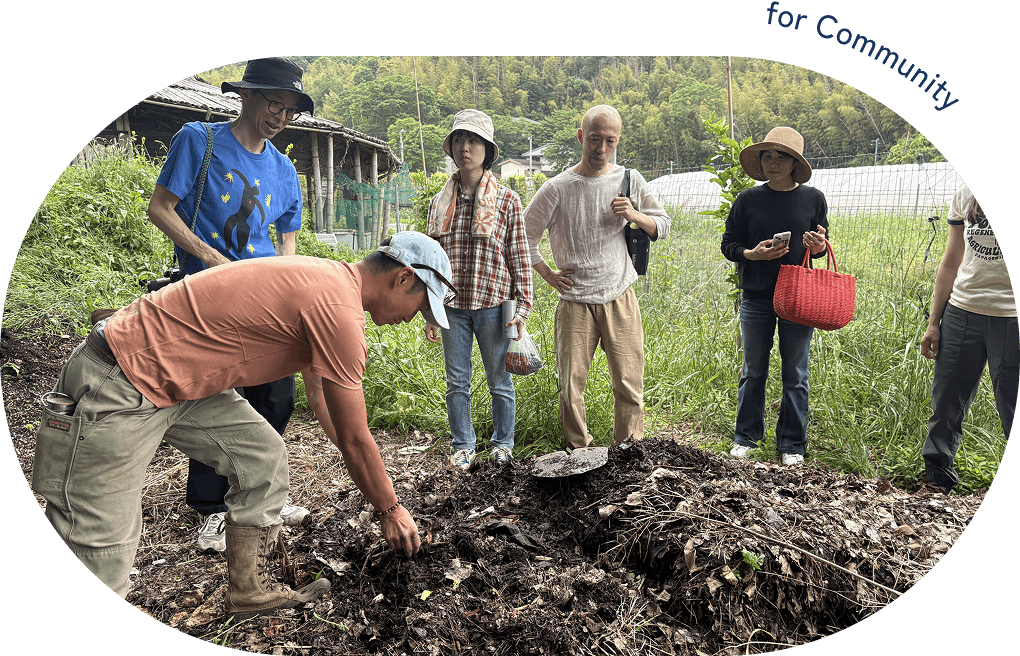 畑で土から何かを掘り出そうとしている人とそれを見ている人たちの写真