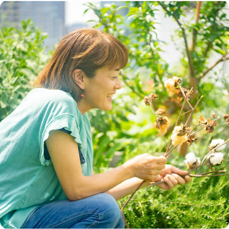 植物を持っている笑顔の女性の写真