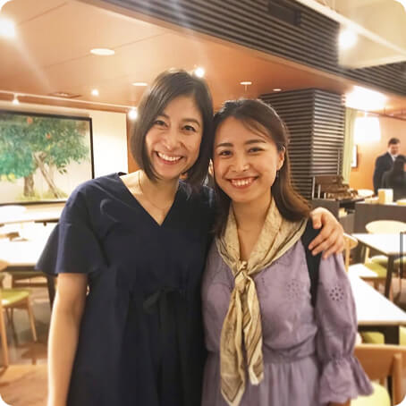 2人で肩を組む笑顔の女性の写真