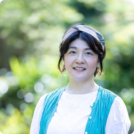 緑の中にいる笑顔の女性の写真