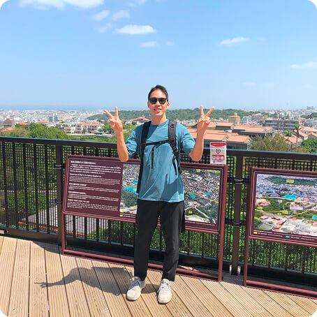 展望台でピースをする男性の写真