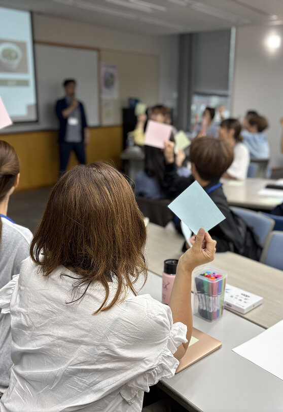色紙を持った手を挙げている人たちの写真