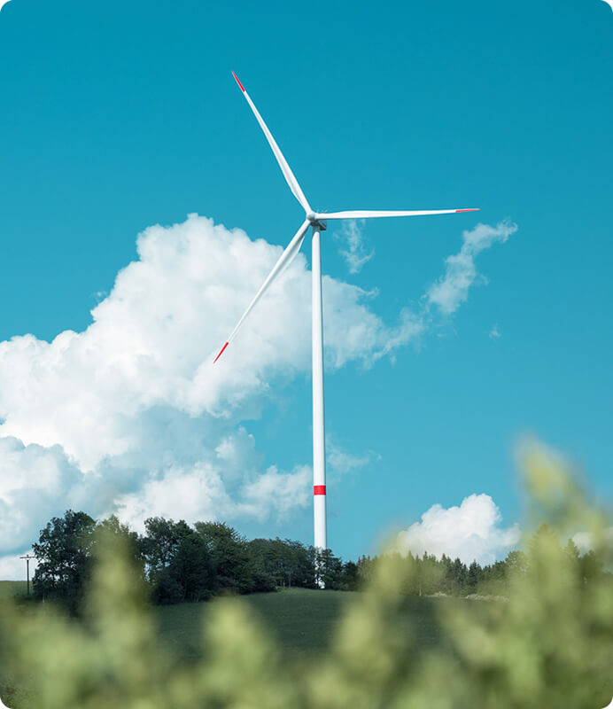 青空に風力発電のタービンが立っている写真