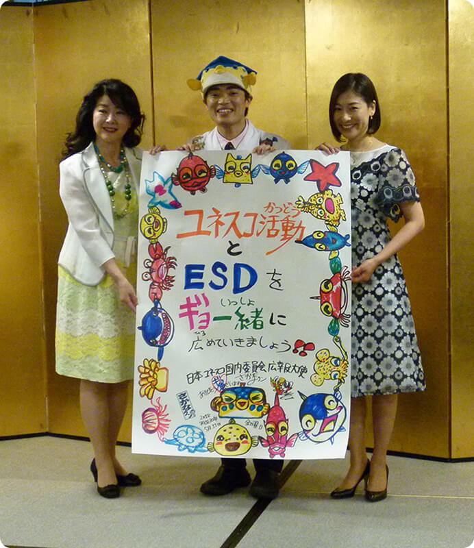 ポスターを持って立っている笑顔の日本ユネスコ国内委員会広報大使3人の写真