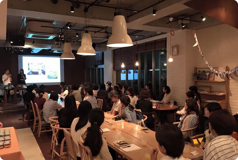 スライドを見つめる人たちの後ろ姿の写真