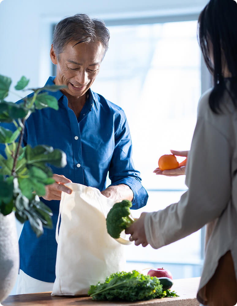 畑でコンテナを持つ笑顔の男性の写真