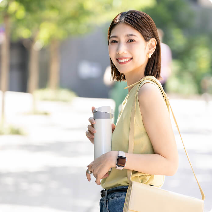 マイボトルを持つ笑顔の女性の写真