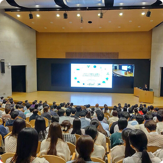 講演を聞く人たちの後ろ姿の写真