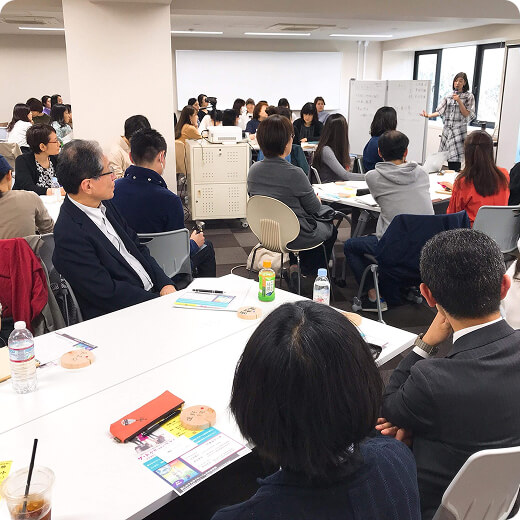 講演をしている代表の姿を見つめる人たちの写真