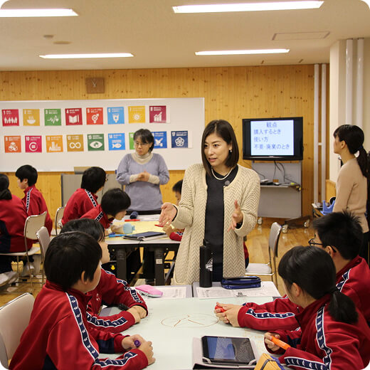 小さいテーブルに座っている人たちに話をする代表の写真